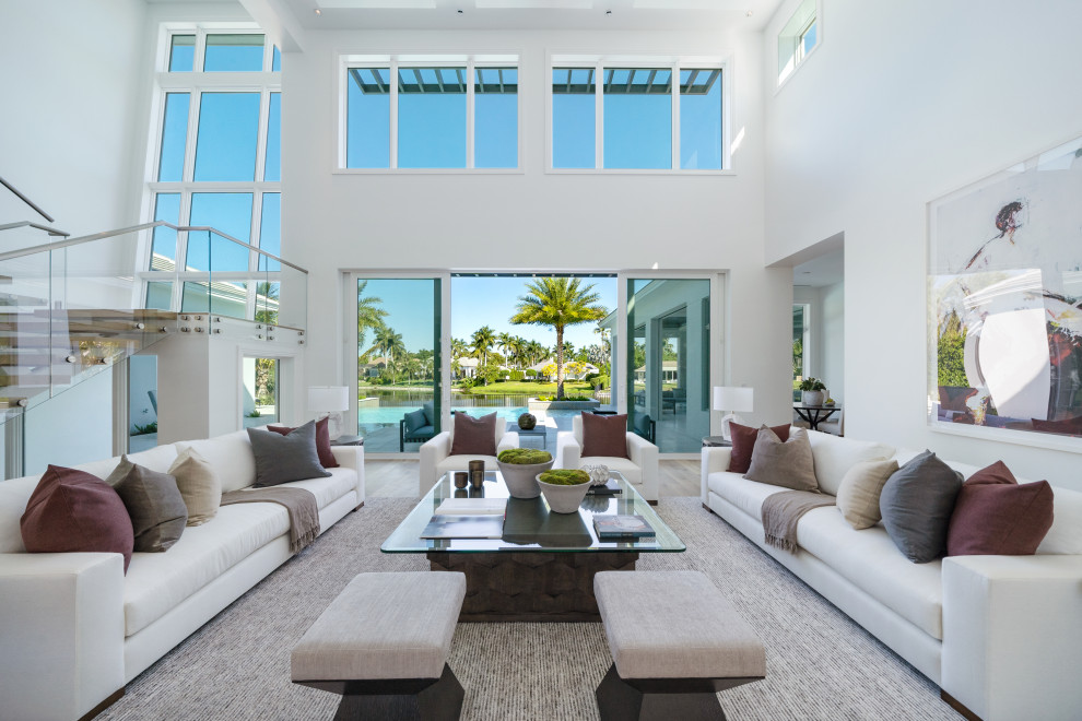 Design ideas for a contemporary open plan living room in Miami with white walls and beige floors.