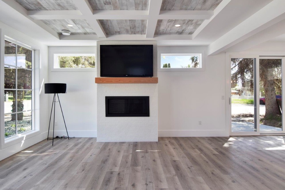 Идея дизайна: открытая гостиная комната среднего размера в стиле кантри с белыми стенами, полом из ламината, горизонтальным камином и телевизором на стене