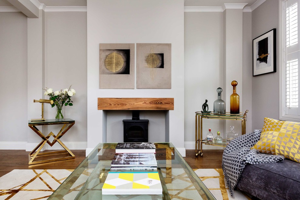 Modelo de salón para visitas abierto clásico renovado con paredes grises, suelo de madera oscura, estufa de leña y suelo marrón
