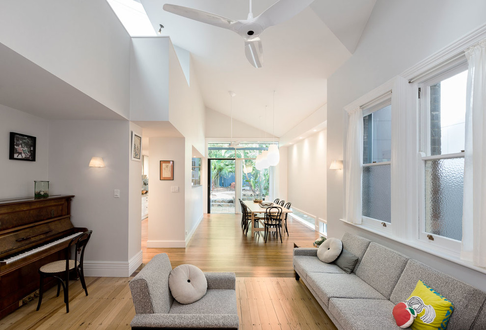This is an example of a medium sized contemporary open plan living room in Sydney with a music area, white walls, light hardwood flooring, no fireplace, no tv and white floors.