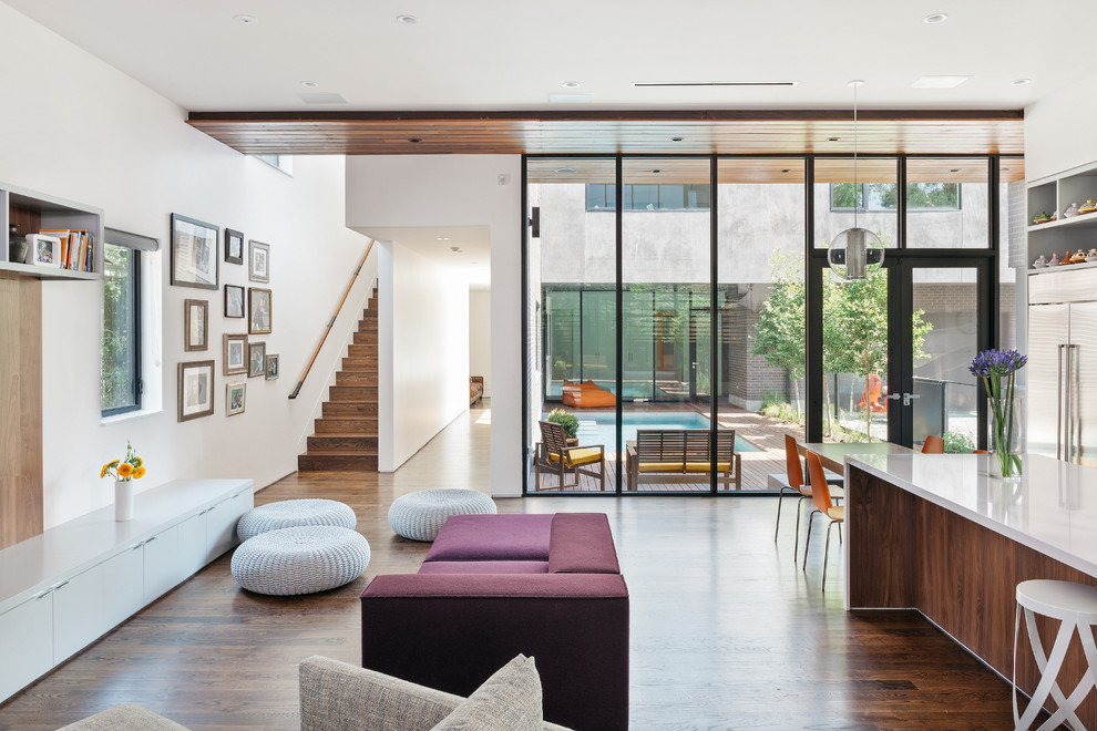 Offenes Modernes Wohnzimmer mit weißer Wandfarbe und braunem Holzboden in Houston