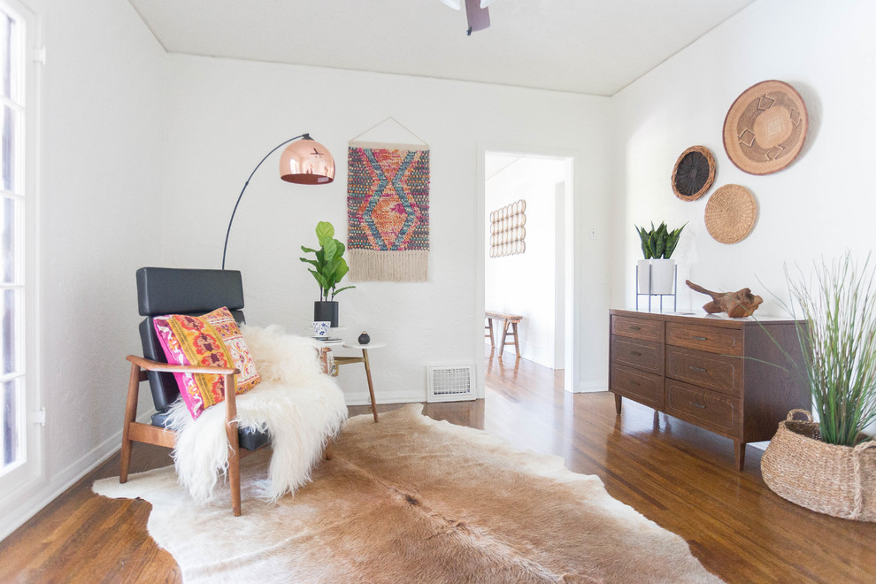 Aménagement d'un salon sud-ouest américain avec un mur blanc, un sol en bois brun et un sol marron.