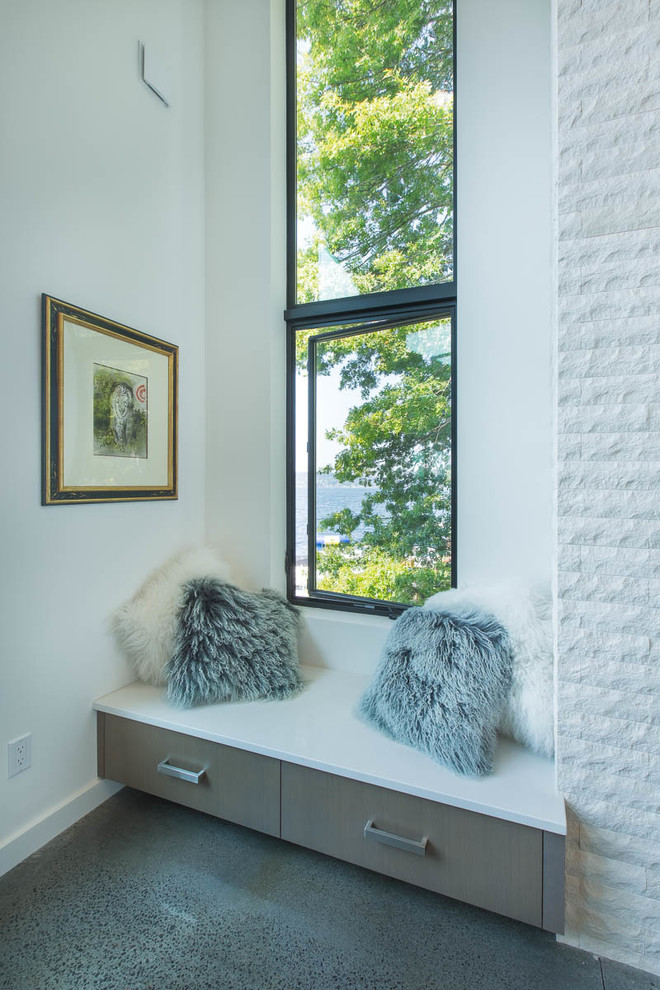Exemple d'un salon tendance de taille moyenne et ouvert avec une salle de réception, un mur blanc, sol en béton ciré, une cheminée standard, un manteau de cheminée en pierre, un téléviseur encastré et un sol gris.