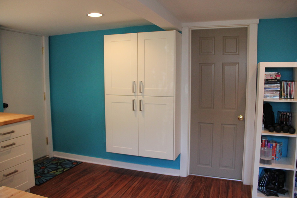 Cette image montre un petit salon traditionnel ouvert avec une salle de réception, un mur bleu, parquet foncé, aucune cheminée, un téléviseur indépendant et un sol marron.