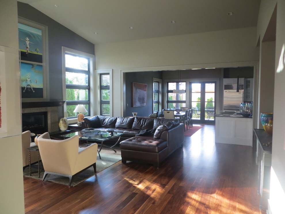Großes, Repräsentatives, Fernseherloses, Offenes Modernes Wohnzimmer mit beiger Wandfarbe, braunem Holzboden, Kamin und Kaminumrandung aus Stein in Seattle