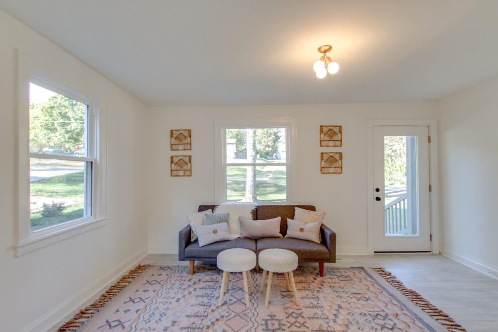 Cette image montre un salon minimaliste de taille moyenne et ouvert avec un mur blanc, parquet clair et un sol blanc.