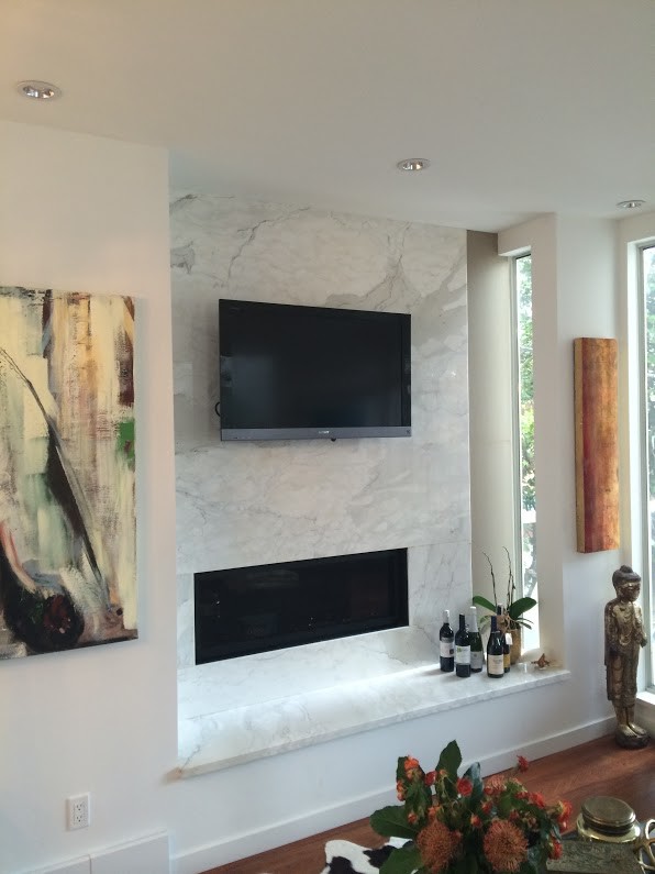 Imagen de salón abierto contemporáneo de tamaño medio con paredes blancas, chimenea lineal, marco de chimenea de baldosas y/o azulejos, suelo de madera en tonos medios y televisor colgado en la pared