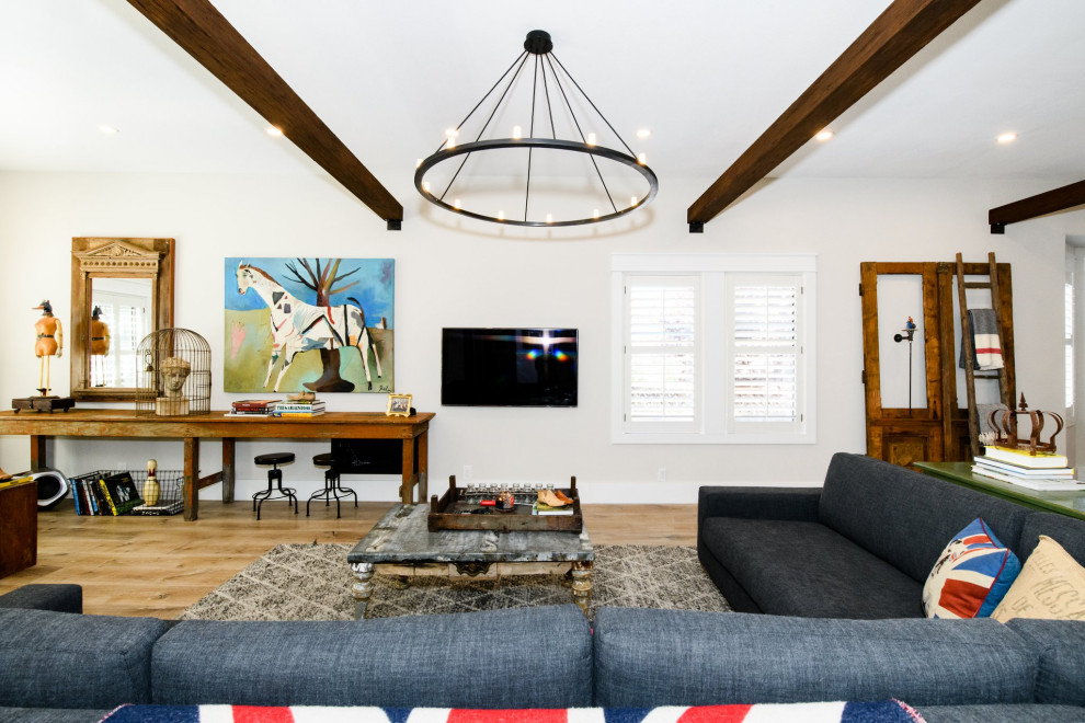 Bild på ett stort lantligt allrum med öppen planlösning, med grå väggar, ljust trägolv, en väggmonterad TV och brunt golv