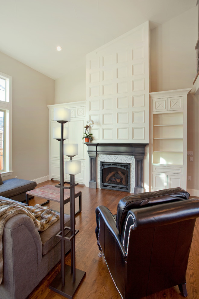 Großes, Repräsentatives, Offenes Klassisches Wohnzimmer mit weißer Wandfarbe, braunem Holzboden, Kamin, Kaminumrandung aus Holz und Multimediawand in Denver