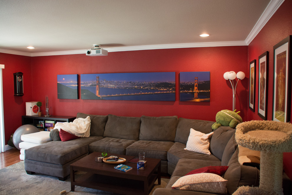 Ejemplo de salón cerrado contemporáneo pequeño con paredes rojas, suelo de madera en tonos medios y televisor colgado en la pared