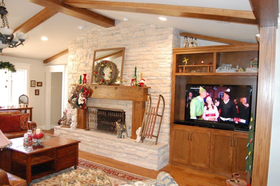Cette photo montre un salon sud-ouest américain de taille moyenne et ouvert avec un mur blanc, parquet clair, une cheminée standard, un manteau de cheminée en pierre et un téléviseur encastré.