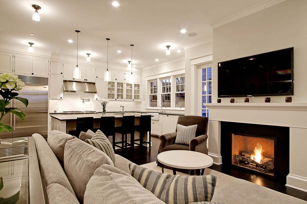 Example of a large classic open concept dark wood floor living room design in Seattle with white walls, a standard fireplace and a wall-mounted tv