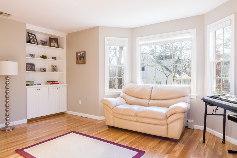 This is an example of a medium sized traditional open plan living room in Boston with a reading nook, beige walls, light hardwood flooring, no fireplace and no tv.