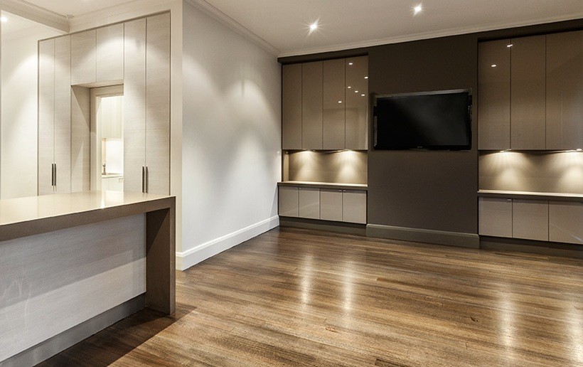 Mittelgroßes, Offenes Modernes Wohnzimmer mit braunem Holzboden, TV-Wand und grauer Wandfarbe in Melbourne