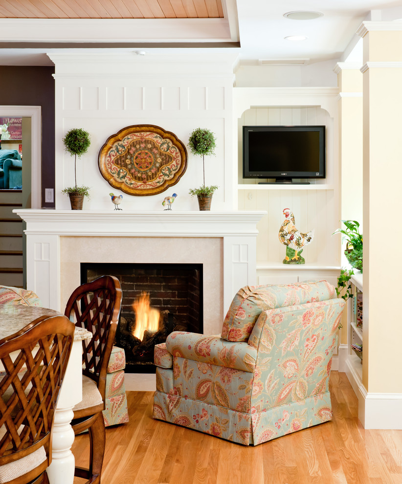 Klassisches Wohnzimmer mit Kamin, freistehendem TV und braunem Holzboden in Boston
