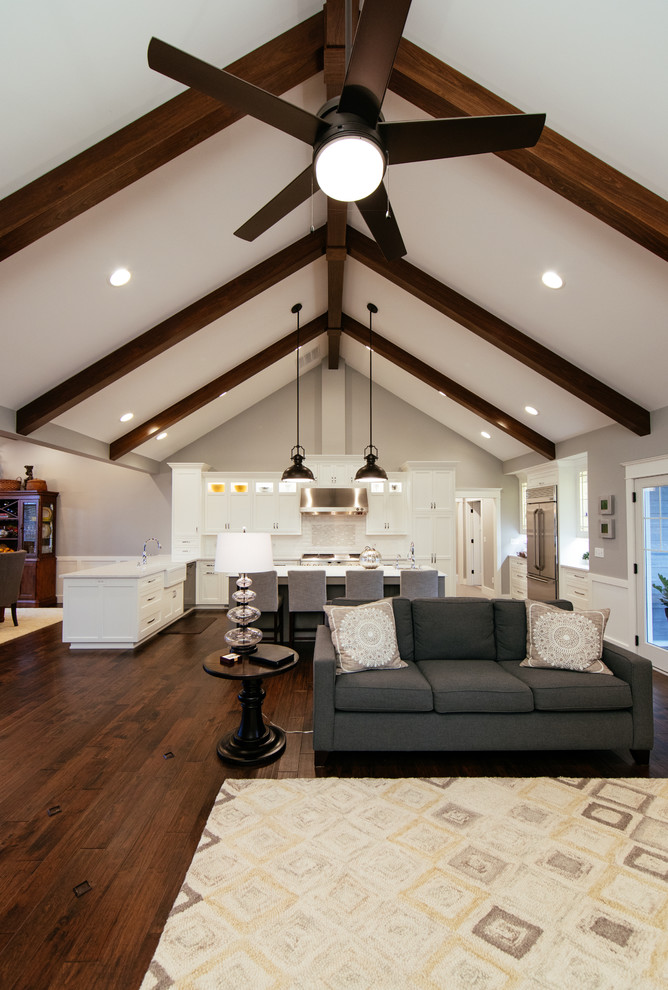 Modelo de salón abierto clásico renovado con paredes beige y suelo de madera oscura