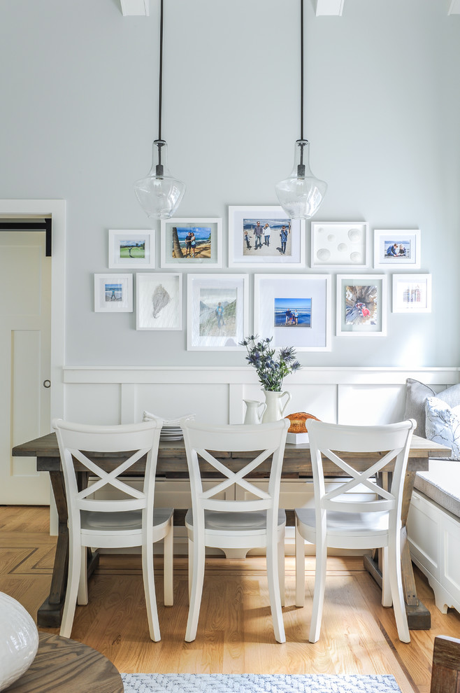 Small nautical dining room in Vancouver with grey walls, light hardwood flooring, a standard fireplace, a tiled fireplace surround and brown floors.