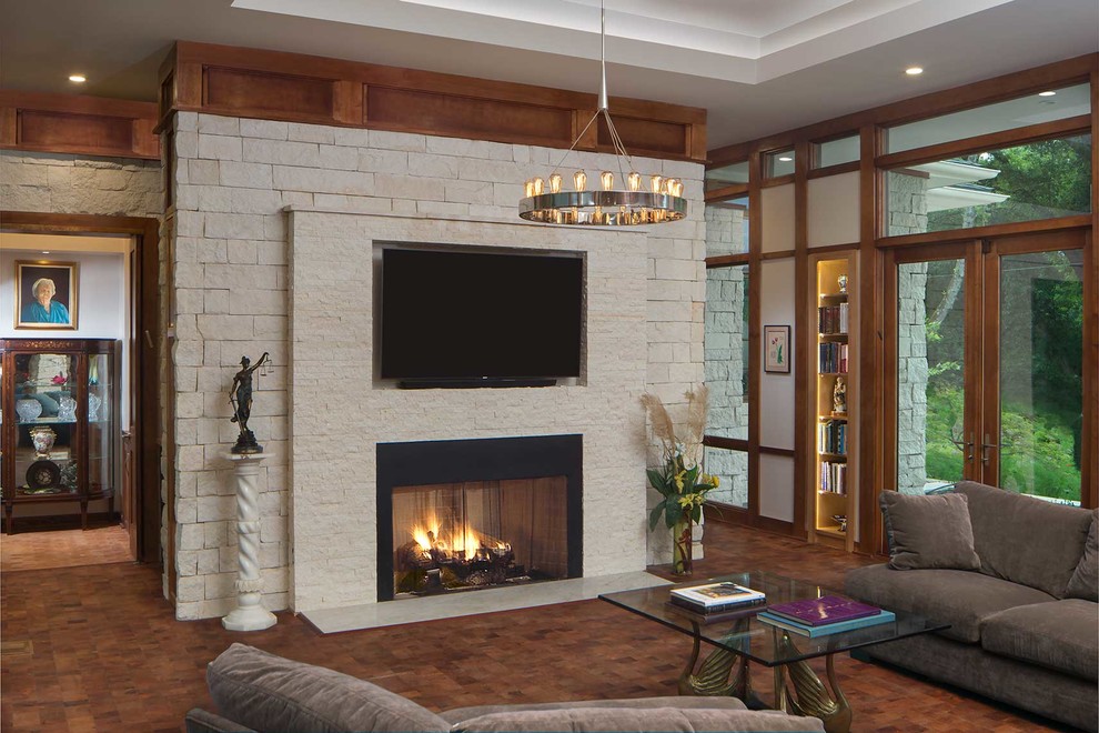 Inspiration for a mid-sized craftsman enclosed dark wood floor and brown floor living room remodel in Atlanta with gray walls, a standard fireplace, a stone fireplace and a wall-mounted tv