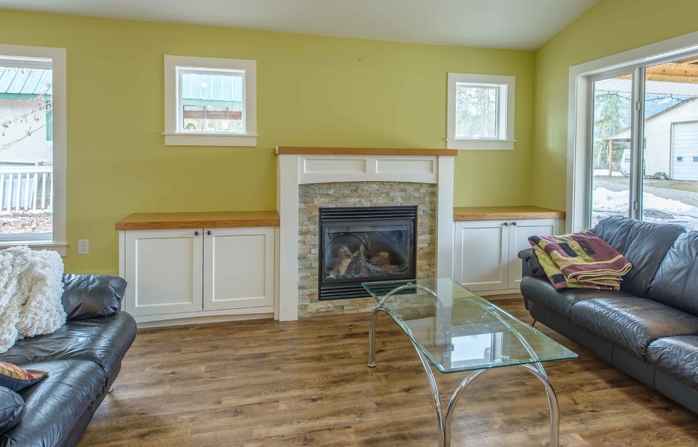 Cette photo montre un petit salon craftsman avec une salle de réception, un mur vert, un sol en vinyl, une cheminée standard, un manteau de cheminée en bois et aucun téléviseur.