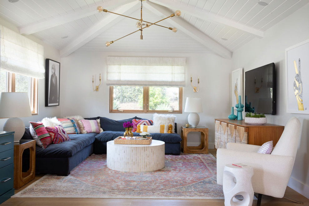 Foto di un soggiorno boho chic aperto con pareti bianche, pavimento in legno massello medio, TV a parete e pavimento marrone