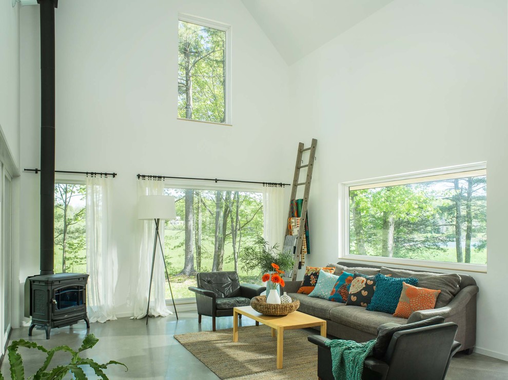 Foto di un grande soggiorno contemporaneo aperto con pareti bianche, pavimento in cemento, stufa a legna, sala formale, nessuna TV e pavimento beige