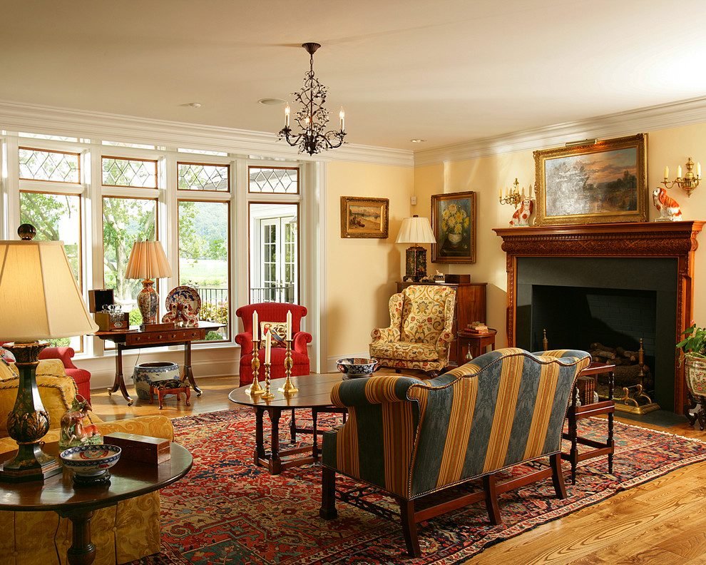 Idéer för stora vintage separata vardagsrum, med ett finrum, gula väggar, mellanmörkt trägolv, en standard öppen spis och en spiselkrans i trä