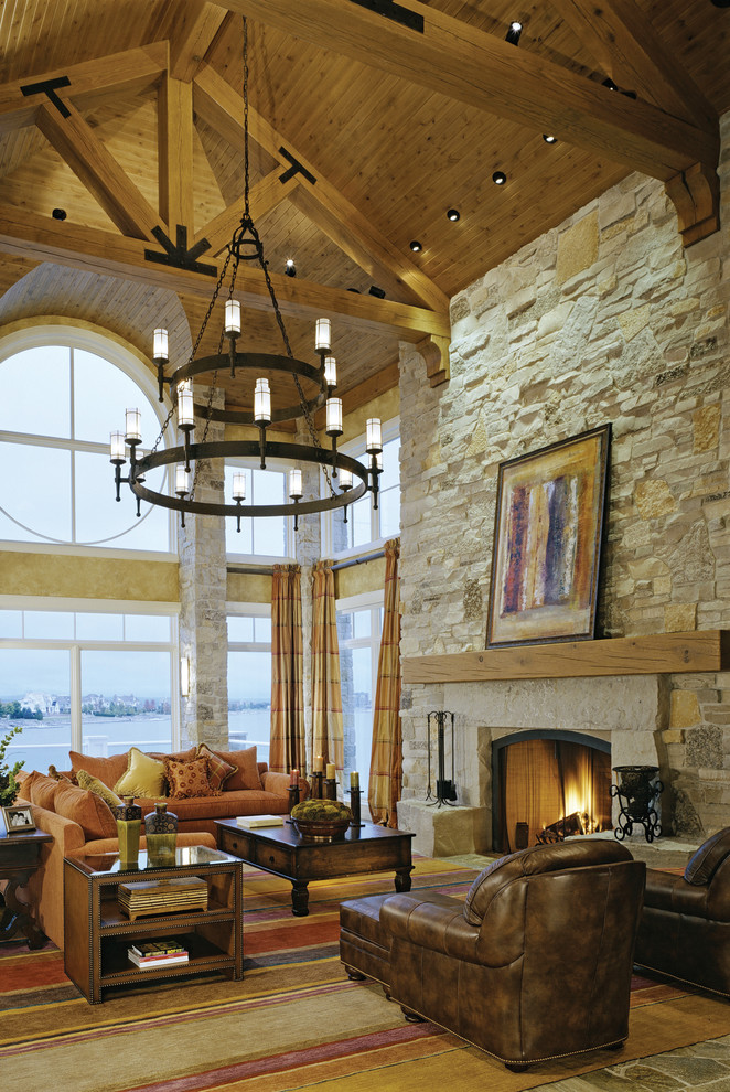 Inspiration for a rustic living room in Milwaukee with a standard fireplace and a stone fireplace surround.