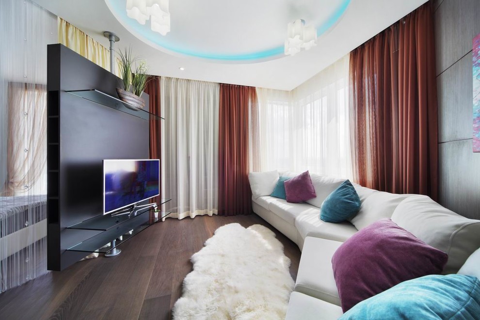 Источник вдохновения для домашнего уюта: открытая гостиная комната в современном стиле с черными стенами, паркетным полом среднего тона, отдельно стоящим телевизором, коричневым полом и тюлем на окнах