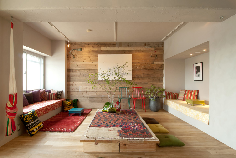 Aménagement d'un salon éclectique avec un mur blanc et un sol en bois brun.