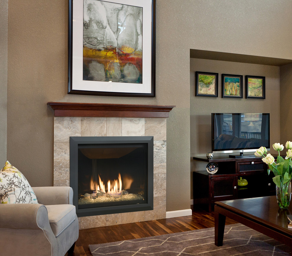 ミネアポリスにあるトラディショナルスタイルのおしゃれなリビング (標準型暖炉、タイルの暖炉まわり、ベージュの壁、濃色無垢フローリング、据え置き型テレビ) の写真
