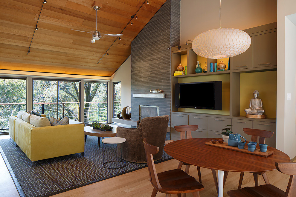 Cette photo montre un salon tendance ouvert avec une salle de réception, un mur multicolore, un sol en bois brun, une cheminée ribbon, un manteau de cheminée en carrelage et un téléviseur fixé au mur.