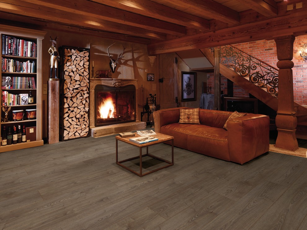 Exemple d'un salon montagne de taille moyenne et fermé avec un mur rouge, sol en stratifié, une cheminée standard, un manteau de cheminée en bois et aucun téléviseur.