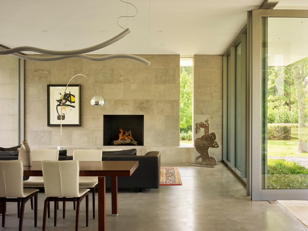 Esempio di un soggiorno design con pavimento in cemento e camino classico