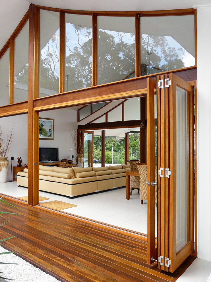 Mid-sized island style open concept porcelain tile living room photo in Brisbane with white walls and a tv stand