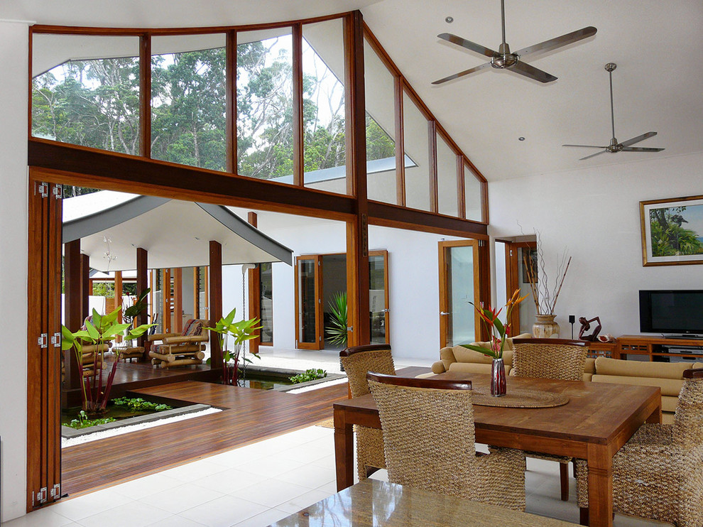 Immagine di un soggiorno tropicale di medie dimensioni e aperto con pareti bianche e pavimento in gres porcellanato
