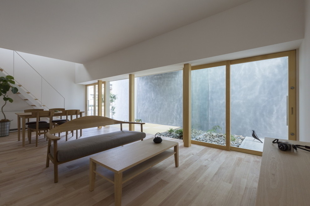 Esempio di un soggiorno di medie dimensioni e aperto con pareti bianche, parquet chiaro, TV autoportante e pavimento beige