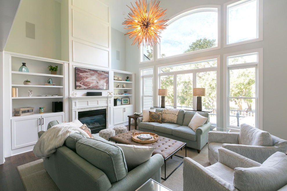 Offenes Klassisches Wohnzimmer mit grauer Wandfarbe, braunem Holzboden, Kamin, TV-Wand, braunem Boden und Wandpaneelen in Charleston
