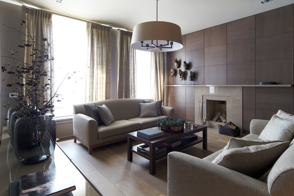 Cette photo montre un salon tendance de taille moyenne et ouvert avec un mur beige, un sol en bois brun, une cheminée standard et un manteau de cheminée en pierre.
