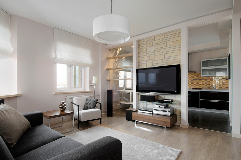 Imagen de salón actual con paredes blancas, televisor colgado en la pared y suelo de madera clara