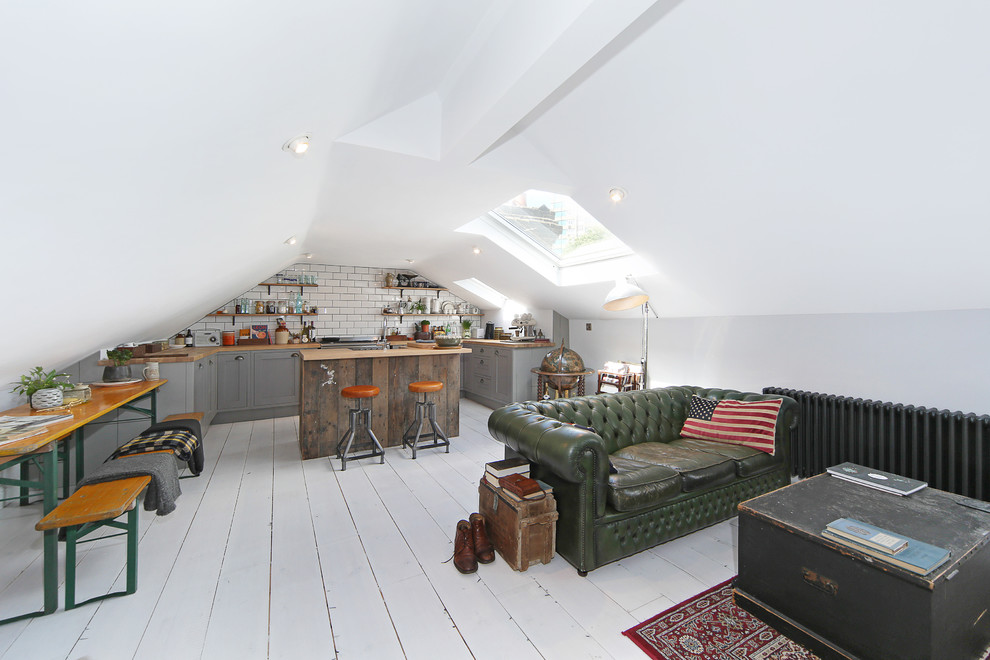 Example of a small danish open concept light wood floor and white floor living room design in London