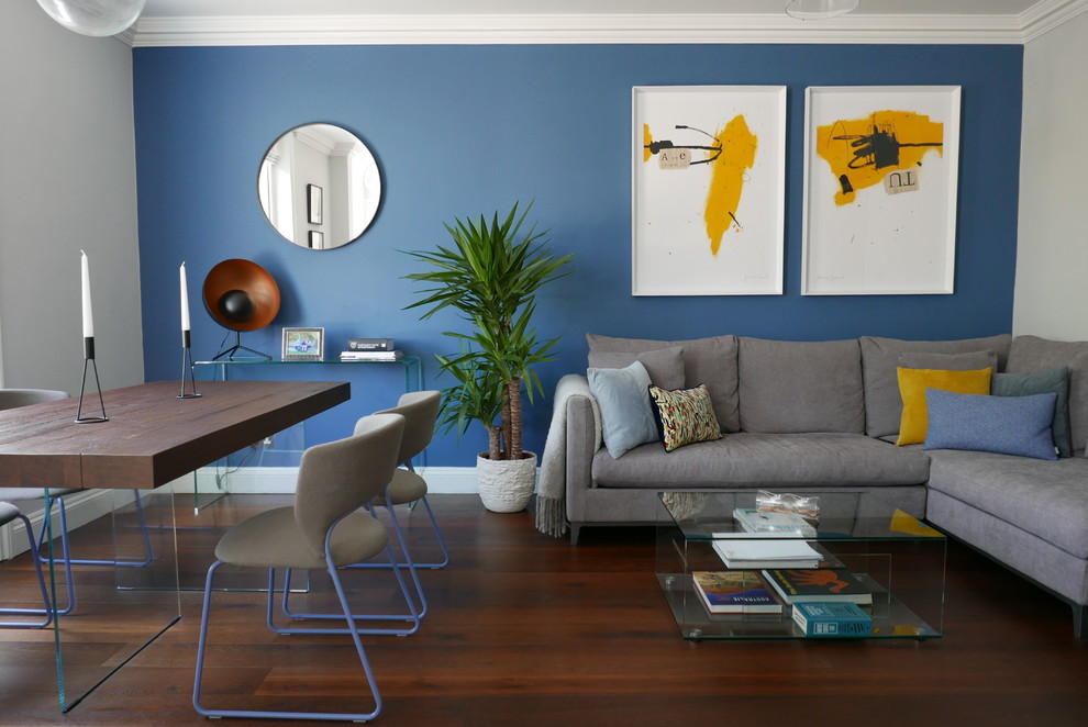 Aménagement d'un petit salon contemporain ouvert avec un mur bleu, parquet foncé, un sol marron et aucune cheminée.