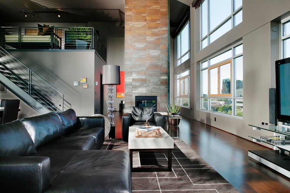 Offenes Modernes Wohnzimmer mit grauer Wandfarbe, freistehendem TV, dunklem Holzboden, Tunnelkamin und gefliester Kaminumrandung in Sacramento