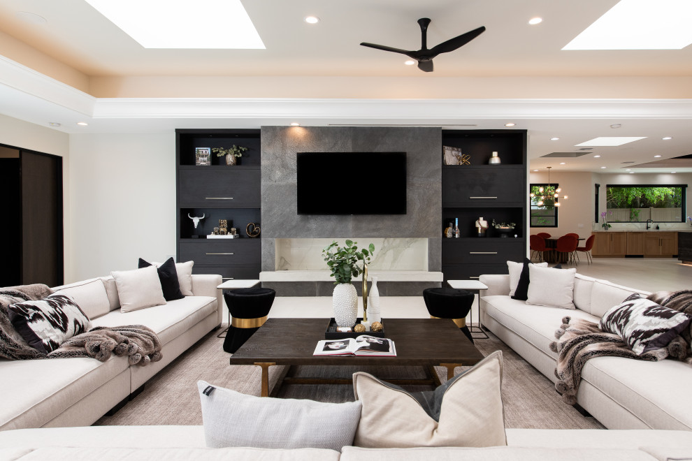 Пример оригинального дизайна: открытая гостиная комната в современном стиле с белыми стенами, телевизором на стене и белым полом