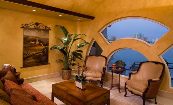 タンパにある小さな地中海スタイルのおしゃれなリビング (黄色い壁、トラバーチンの床、暖炉なし、テレビなし、ベージュの床) の写真