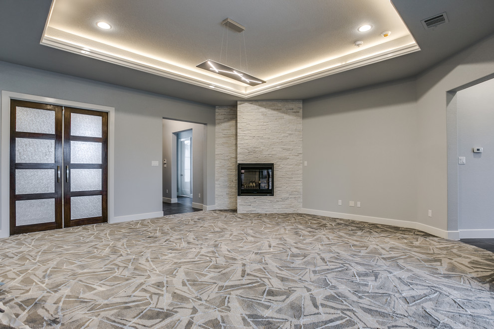 Großes, Offenes Modernes Wohnzimmer mit grauer Wandfarbe, Teppichboden, Eckkamin und Kaminumrandung aus Stein in Dallas