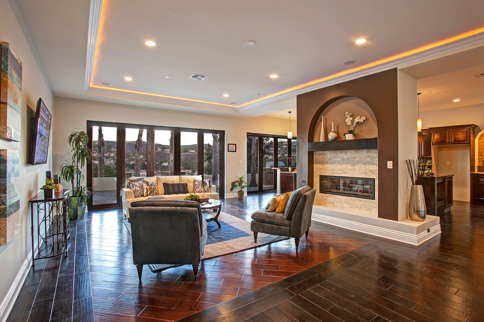 Photo of a large traditional formal open plan living room in Orange County with beige walls, dark hardwood flooring, a two-sided fireplace, a stone fireplace surround and a wall mounted tv.