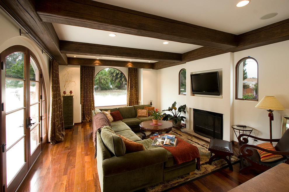 Living room - craftsman enclosed medium tone wood floor living room idea in San Diego with a wall-mounted tv