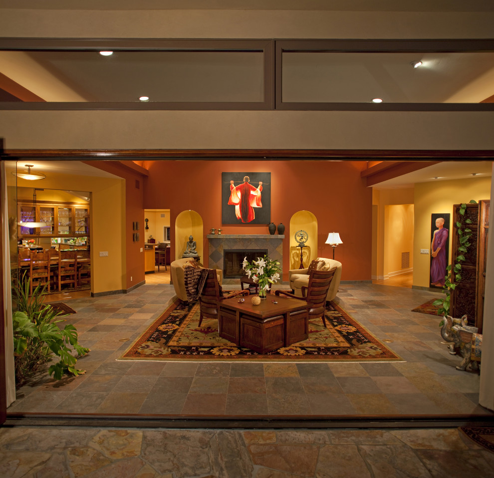 Идея дизайна: огромная открытая гостиная комната в стиле фьюжн с разноцветными стенами, полом из сланца, стандартным камином и фасадом камина из камня