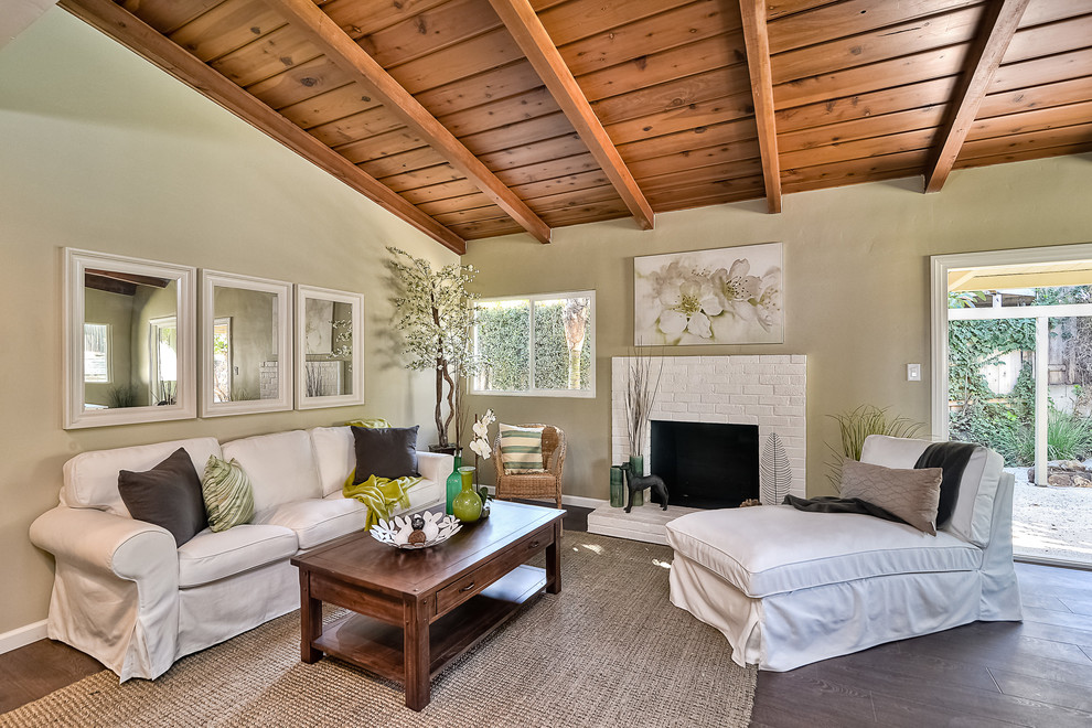 Aménagement d'un petit salon classique avec un mur vert, sol en stratifié, une cheminée standard et un manteau de cheminée en brique.