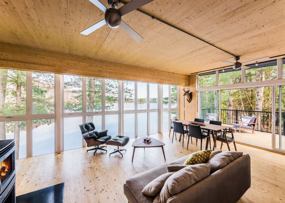 Offenes Skandinavisches Wohnzimmer mit hellem Holzboden und Kaminofen in Ottawa